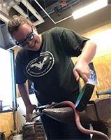 Ashley Smith using a grinder on an art project.